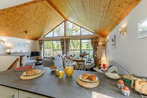 una cocina y una sala de estar con una mesa con comida. en Milton Lodge, en Little Petherick