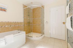 Un baño con ducha, bañera y lavabo. en Milton Lodge, en Little Petherick 24 fotos más