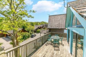 Un patio con una mesa y sillas en una terraza. en Milton Lodge, en Little Petherick