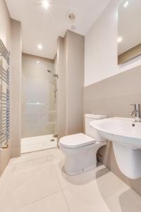 a white bathroom with a toilet and a sink at Kittiwake Padstow in Padstow +21 photos