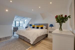 a bedroom with a bed and a vase of flowers at Kittiwake Padstow in Padstow