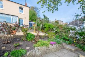 a garden with a bench and some plants at Honey Cottage in Richmond