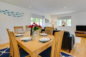 a dining room and living room with a wooden table and chairs at Valley View in Mevagissey