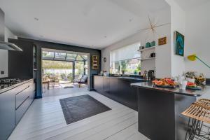 a kitchen with black and white cabinets and a table at Pen Y Mor in Mawgan Porth +20 photos