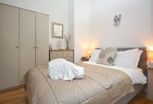 a bedroom with a bed with white sheets on it at Tregerrick in Padstow