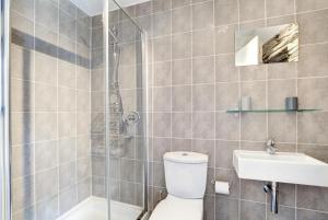 a bathroom with a shower and a toilet and a sink at Tregerrick in Padstow +9 photos