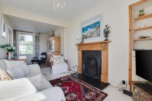 a living room with a white couch and a fireplace at Stargazy in Mousehole