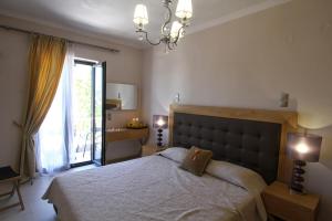 a bedroom with a large bed and a window at Ilioxenia Chios Studios & Apartments in Paralia Agias Foteinis