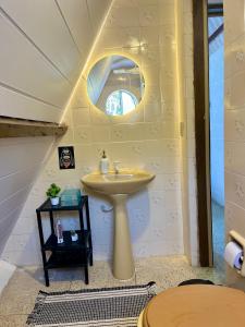 a bathroom with a sink and a mirror at Casa estilo chale dúplex com 3 quartos, churrasqueira, balanço, chuveirão e a uma quadra da praia in Mangaratiba +39 photos