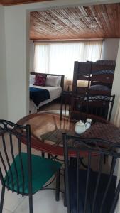 a living room with a table and chairs and a couch at Alojamiento natural rural LOS NOGALES, apartamentos tipo glamping, avistamiento de aves, paisaje cafetero in San Francisco