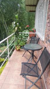 a patio with a table and two chairs on a porch at Alojamiento natural rural LOS NOGALES, apartamentos tipo glamping, avistamiento de aves, paisaje cafetero in San Francisco