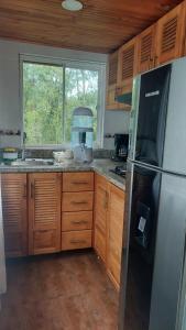 a kitchen with a stainless steel refrigerator and wooden cabinets at Alojamiento natural rural LOS NOGALES in San Francisco