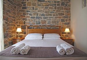 a bedroom with a bed with towels on it at Kalo Nero Apartments in Makry Gialos