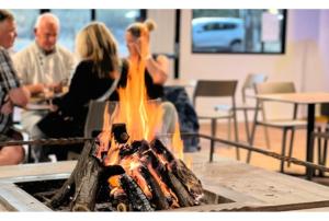 a group of people sitting around a fire pit at Discovery Resorts - Kings Canyon in Kings Canyon