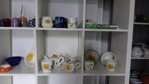 un estante lleno de tazas, platos y tazones en Sunflower Accommodation, en Liubliana