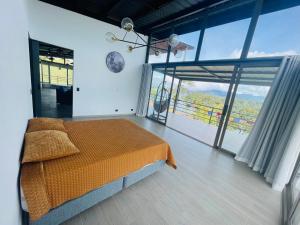 a bedroom with a bed and a large window at Casa garuda, hermosa cabaña con vista a la piedra de El Peñol in La Pradera +39 photos