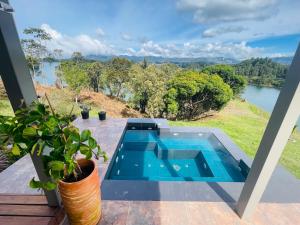 a swimming pool on a patio with a view of a river at Casa garuda, hermosa cabaña con vista a la piedra de El Peñol in La Pradera
