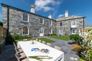 a stone building with a table and chairs in front of it at Marine Villa in Padstow
