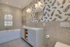 a bathroom with a sink and a tub and a mirror at Marine Villa in Padstow +38 photos