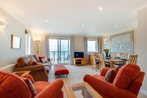 sala de estar con sillas de color naranja y comedor en Flat 20 Clifton Court, en Croyde