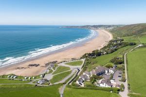 Una vista aérea de una playa con casas y el océano. en Flat 20 Clifton Court, en Croyde