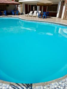 una piscina con sedie blu e una casa di Hotel Nuestro Amo a Sayán