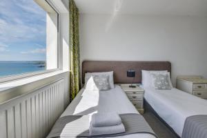 Praa SandsSeacroft Barton的有窗户的房间里有两张床