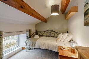 a bedroom with a bed and a window at High Green Cottage in Low Eskcleth