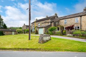 a sign in the grass in front of a house at High Green Cottage in Low Eskcleth