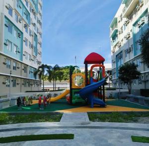 a playground in front of a building with a slide at DaLei 3- 103 Sleeps 8pax at Marina Spatial Condominium in Dumaguete City in Dumaguete