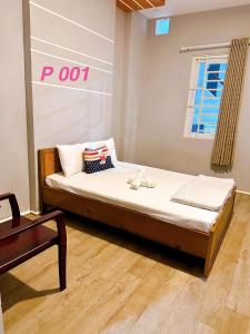 ein Schlafzimmer mit einem Bett in einem Zimmer mit einem Schild in der Unterkunft Mini hotel Trịnh Huỳnh in Phan Thiet + 2 Fotos
