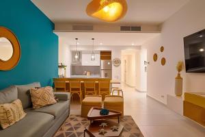 Una sala de estar y una cocina con un sofá y una mesa. en Caribbean Bliss on the Beach, en Juan Dolio