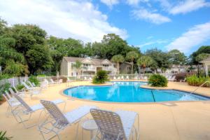 una piscina con tumbonas y una mesa en Ocean Walk E-5, en Saint Simons Island
