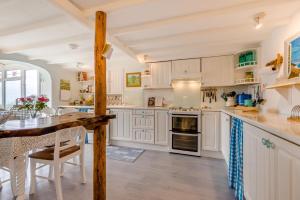 eine Küche mit weißen Schränken und einem Holztisch in der Unterkunft Trevalley in Treknow + 30 Fotos