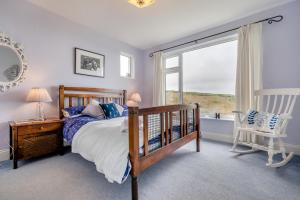 ein Schlafzimmer mit einem Bett, einem Fenster und einem Stuhl in der Unterkunft Trevalley in Treknow