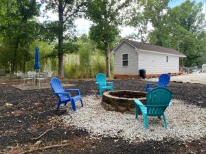 un gruppo di sedie seduti intorno a un focolare di Frog Hollow a Townville