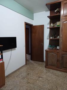 Una sala de estar con un televisor de pantalla plana en una pared. en Apartamento inteiro Cop 30, en Belém