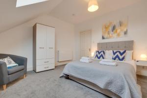 ein Schlafzimmer mit einem großen Bett und einem Stuhl in der Unterkunft The Ambleside Loft in Ambleside