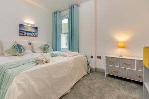 Un dormitorio con dos camas y una ventana. en Summer Breeze - St Ives, en St Ives