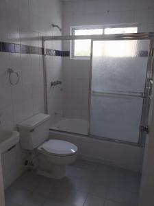 a white bathroom with a toilet and a shower at Tropical Optimal Tropicana Sur in Sosúa