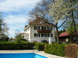 a house with a swimming pool in front of a house at Landhaus Löwenzahn in Unteregg