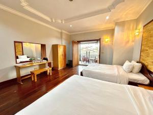 a hotel room with two beds and a desk at Youth's Dream Fulfillment Association in Siem Reap
