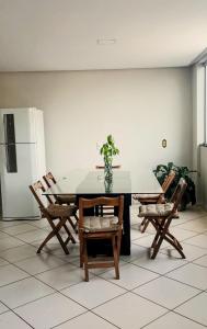 una sala da pranzo con tavolo, sedie e frigorifero di Hospedaria Em Lagoa - Apto 102 - Residencial Cota a Lagoa da Prata