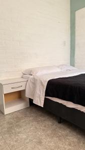 Un dormitorio con una cama y una mesita de noche al lado. en Sol Campestre, en La Adela