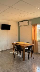 una mesa en una habitación con sillas alrededor en Sol Campestre, en La Adela 15 fotos más