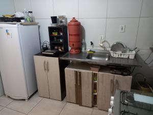 a small kitchen with a sink and a refrigerator at Hostel Luz in Lençóis