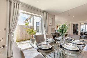 Un comedor con una mesa de cristal y sillas. en Scarlettrose, en Great Torrington