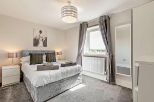 Un dormitorio con una cama grande y una ventana. en Scarlettrose, en Great Torrington