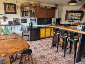 a kitchen with a counter and some bar stools at Hostal Boutique El Vergel Azul in Castro +107 photos