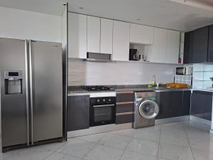 a kitchen with a refrigerator and a washing machine at Figo Apartamentos in Praia +10 photos